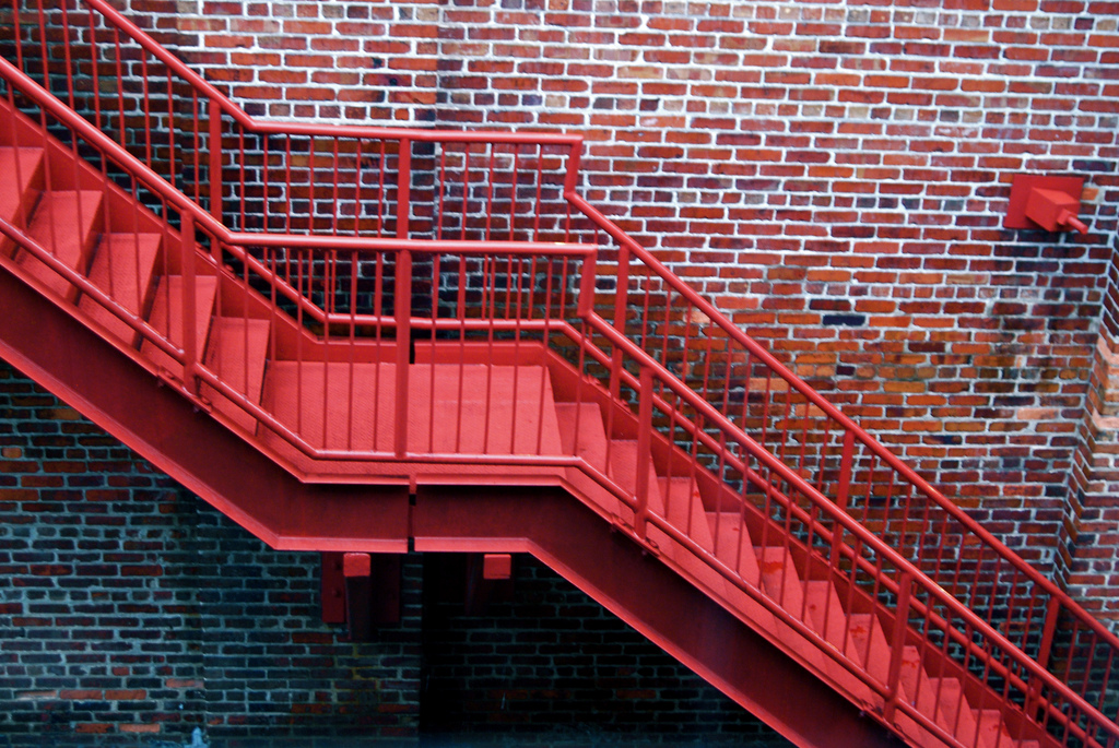 red metal staircase on a brick wall